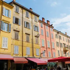 Färgglada hus med persienner i Emilia-Romagna. En solig dag på en italiensk piazza.