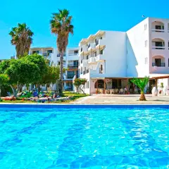 Basen i białe budynki hotelowe z palmami. Wiele osób odpoczywa na leżakach. Ocean Heights View Hotel opinie - idealne miejsce na wakacje.