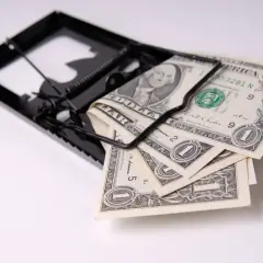 Pułapka na pieniądze, gdzie banknoty dolarowe kuszą jak przynęta, symbolizując potencjalny okres karencji w finansach.
