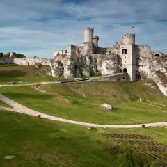 Ruiny zamku Olsztyn k Częstochowy na wapiennym wzgórzu, z polami i lasami w tle.