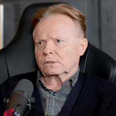 Michał Bajor siedzi w fotelu, przed mikrofonem, z nagrodą YouTube w tle.