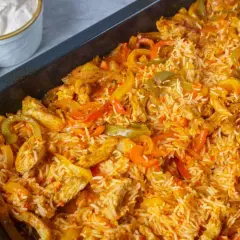 Reis im Backofen mit Hähnchenstreifen und bunten Paprikastreifen. Eine köstliche Mahlzeit, die im Ofen zubereitet wird.