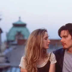 Jesse e Celine, protagonisti della trilogia before, si guardano intensamente sui tetti di Vienna.