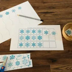 Actividades invierno Montessori: hojas con copos de nieve para recortar y completar patrones. Tijeras y lápiz listos.