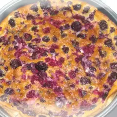Un délicieux clafouti aux fruits rouges, tout juste sorti du four, avec ses myrtilles et framboises fondantes.