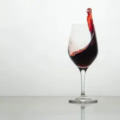 Ein Glas Rotwein mit einer dynamischen Welle, die die Frage aufwirft, wie schmeckt wein.
