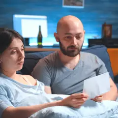 Zmartwieni rodzice czytają list. Martwią się, czy komornik może zająć rentę rodzinną na dziecko.
