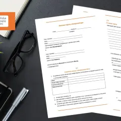 Dwa dokumenty umowy najmu okazjonalnego leżą na biurku obok okularów i rośliny.
