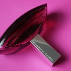Różowa butelka Euphoria Intense Calvin Klein, woda perfumowana, lśni na tle intensywnego różu.