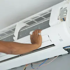 Mano ajustando el cepillo para limpiar la turbina del aire acondicionado.