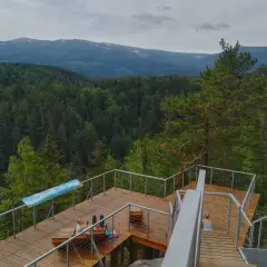 Drewniany taras z widokiem na góry i las. Idealne miejsce na relaks w Karpaczu, restauracja z widokiem zachwyca.