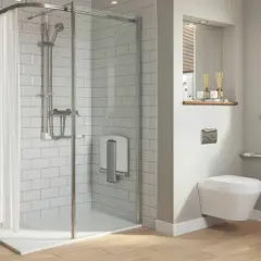 Salle de bain moderne avec douche de sol, carrelage blanc, porte-serviettes chauffant et WC suspendu avec barres d'appui.