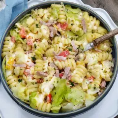 En stor skål med krämig pastasallad, perfekt för ett sommarmåltid. Detta pastasallad recept är fullt av goda ingredienser.
