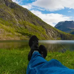 Idealny weekend w górach: relaks nad jeziorem, w otoczeniu zielonych zboczy i wodospadu.