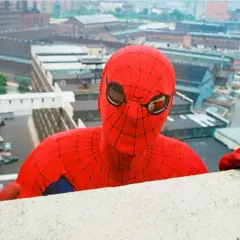 Le premier Spiderman acteur, Nicholas Hammond, se penche au-dessus d'un mur, regardant la ville.