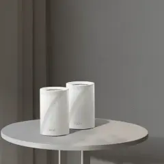 Un routeur extérieur sur un poteau et deux routeurs Deco sur une table. Ces appareils connectent votre maison à Internet.