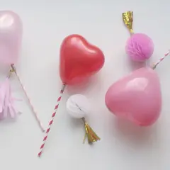 Balony w kształcie serc na patyczkach z ozdobami.