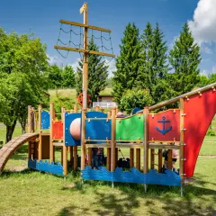 Kolorowy plac zabaw w kształcie statku pirackiego, oferujący mnóstwo atrakcji dla dzieci w Brzegu. Idealne miejsce na letnie zabawy.