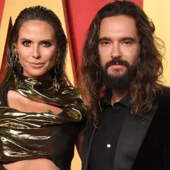 Heidi Klum i Tom Kaulitz na czerwonym dywanie, ona w złotej kreacji, on w czarnym garniturze.
