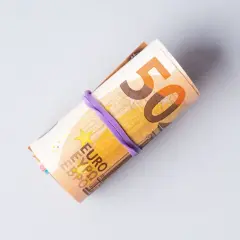 Zrolowane banknoty euro, widoczna cyfra 50. Symbolizują ceny w Niemczech i koszty życia.