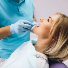 Dentysta bada ząb pacjentki, by ustalić, dlaczego boli.