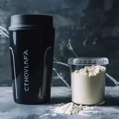 Czarny shaker i pojemnik z białym proszkiem. To suplementy, które pomogą Ci zrozumieć, cytrulina co daje.