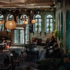 Wnętrze pełne uroku, z dużymi, okrągłymi lampami i zielonymi akcentami. Idealne miejsce na relaks w jednej z klimatycznych restauracji w Krakowie.