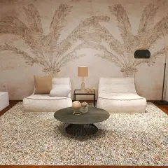 Gemütliche Sitzsäcke und ein runder Couchtisch laden zum puristisch wohnen ein. Die Wandtapete mit Palmenmotiv und der Teppich schaffen eine entspannte Atmosphäre.
