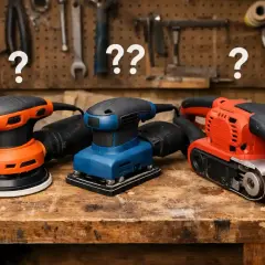 Trois ponceuses électriques, un outil manuel pour creuser le bois, sur un établi.