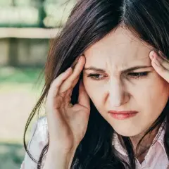 Kobieta z bólem głowy, która sięga po ibuprofen Hasco.