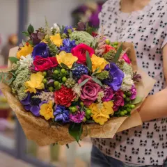 Kolorowy bukiet kwiatów, idealny na imieniny Agnieszki. Różowe róże, fioletowe anemony i żółte frezje tworzą radosną kompozycję.