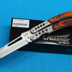 Navaja Crossnar con mango de madera anaranjada y detalles plateados, lista para la acción.