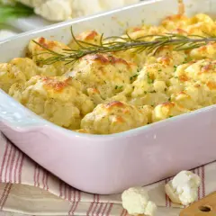 Cavolfiore al forno con pangrattato e formaggio fuso, guarnito con rosmarino fresco. Un piatto invitante e saporito.