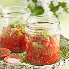Zwei Gläser mit Tomaten-Chiasamen-Mischung, inspiriert von gesunden Chiasamen Rezepten. Daneben kleine Schälchen mit Salz und Pfeffer.