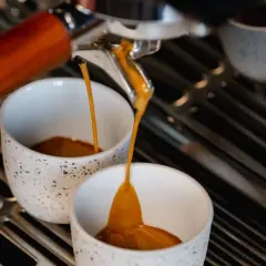 Espresso fließt in zwei Tassen. Hoffentlich ist der Kaffee zu sauer, sonst ist er perfekt.