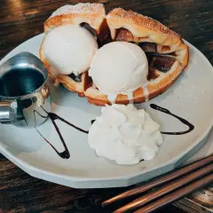 Pyszne bacio lody na ciepłym gofrze z bitą śmietaną i polewą czekoladową. Idealny deser na każdą okazję.