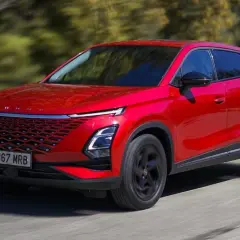 Czerwony SUV, jeden z nowych chińskich samochodów, jedzie po drodze.