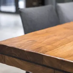 A close-up of a beautiful acacia wood table, showcasing its rich grain and warm tones. Is acacia wood good? This table suggests yes!