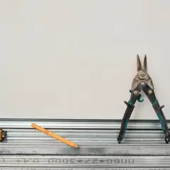 Outils pour comment couper un rail de placo : cisaille, mètre, crayon. Prêt à construire !