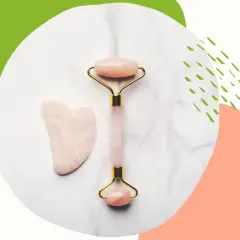 Różowy roller i kamień gua sha – idealne do tego, czym masować twarz dla relaksu i pięknego wyglądu.
