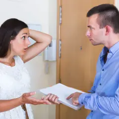 Un homme explique à une voisine comment faire une pétition de voisinage. Elle semble surprise et perplexe.