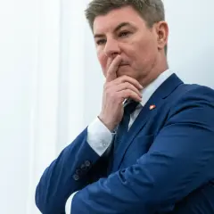 Jan Grabiec w garniturze, zamyślony, z palcem przy ustach. Może myśli o przyszłości dzieci?