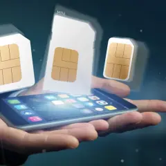 Dłoń trzyma smartfon, nad którym unoszą się karty SIM różnych rozmiarów, symbolizujące aktywację karty SIM i wybór odpowiedniego formatu.