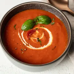 Eine cremige, vegane Tomatensuppe mit Basilikum und einem Klecks Sahne. Perfekt für kalte Tage.