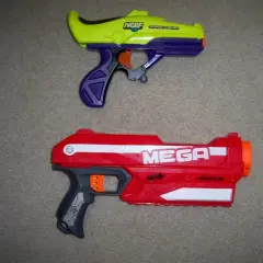 Dwa pistolety Nerf: żółto-fioletowy i czerwony Nerf Magnus.