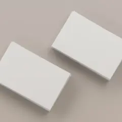 Dwie stosy białych wizytówek na neutralnym tle. Idealne do nauki, jak wydrukować wizytówki.