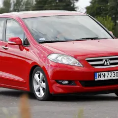 Czerwona Honda FR-V w ruchu drogowym, z widocznym numerem rejestracyjnym WN 72305.
