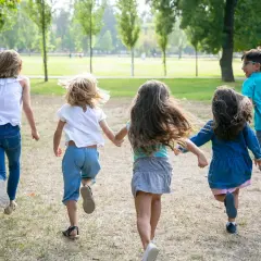 Niños corriendo en un parque, disfrutando de la **infantil primavera**.