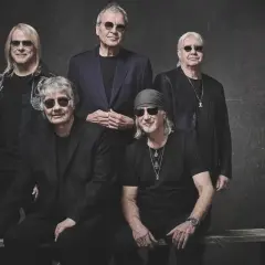 Pięciu członków Deep Purple w czarnych strojach i okularach przeciwsłonecznych pozuje do zdjęcia.