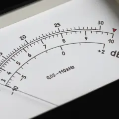 Wskaźnik miernika pokazuje poziom dźwięku w decybelach (dB). Skala obejmuje wartości od -10 do 30 dB, z dodatkowymi oznaczeniami mV/V.